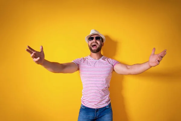 Estudio de tiro de hombre barbudo amistoso positivo en traje despojado de moda y sombrero tirando de las manos hacia la cámara, invitando a los compañeros a entrar, dando la bienvenida a los invitados a la fiesta — Foto de Stock