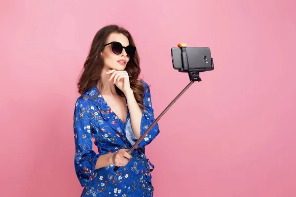 Jonge vrouw in blauwe jurk en zonnebril selfie te nemen — Stockfoto