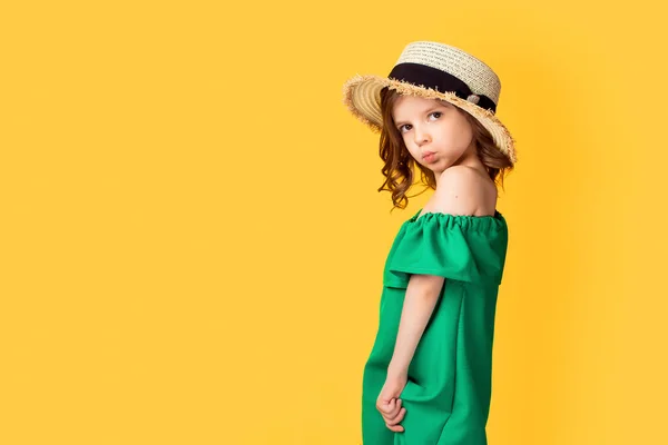 Маленькая девочка в платье и шляпе в студии — стоковое фото