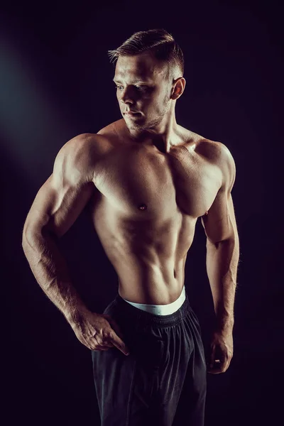 ボディービルポーズ。フィットネス筋肉男暗い背景に. — ストック写真