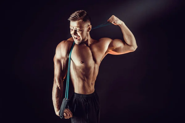 Muž fitness cvičení s protahováním kapela ve studiu. — Stock fotografie