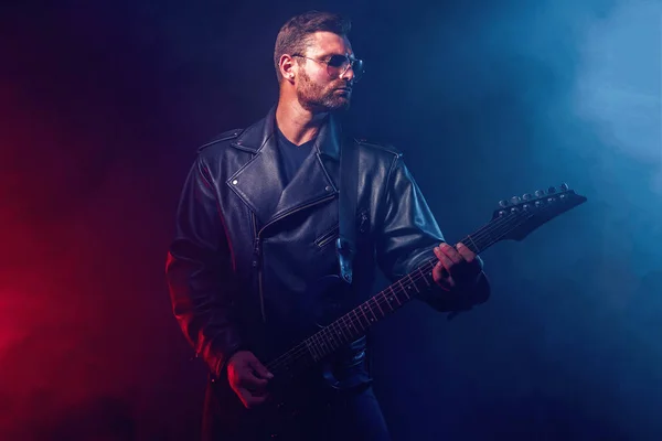 Heavy metal musician is playing electrical guitar. Shot in a studio. — Stock Photo, Image