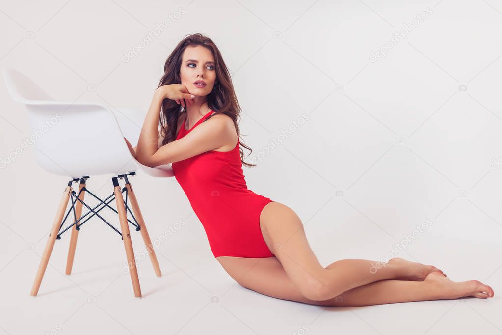 Woman in swimsuit leaning on chair
