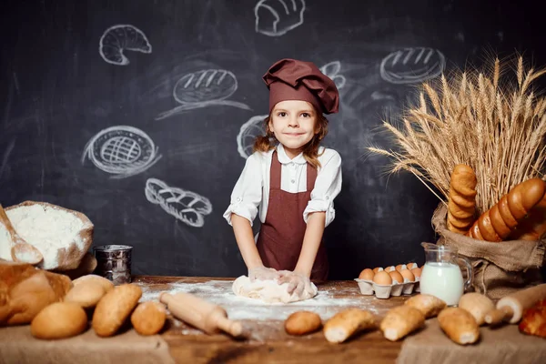 Küçük kız masada hamur yoğurma