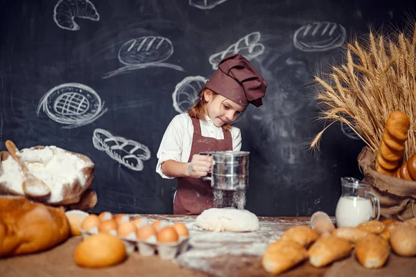 Küçük kız masada hamur yoğurma