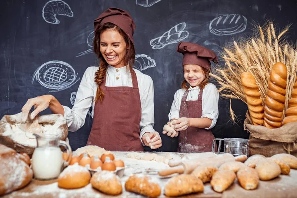 Kvinna och flicka att göra bakverk tillsammans — Stockfoto