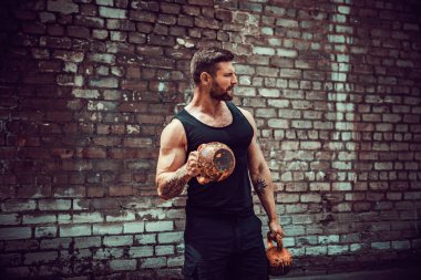 Atletik bir adam bir kettlebell ile çalışma dışarı. Güç ve motivasyon