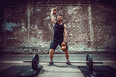 Atletik bir adam bir kettlebell ile çalışma dışarı. Güç ve motivasyon