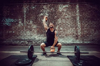 Atletik bir adam bir kettlebell ile çalışma dışarı. Güç ve motivasyon