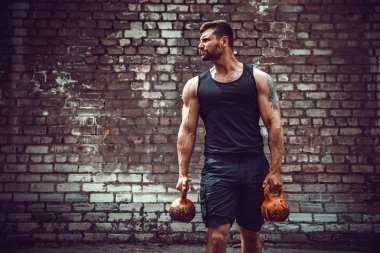 Atletik bir adam bir kettlebell ile çalışma dışarı. Güç ve motivasyon