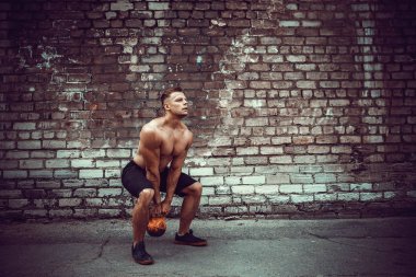 Atletik bir adam bir kettlebell ile çalışma dışarı. Güç ve motivasyon