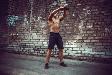 Atletik bir adam bir kettlebell ile çalışma dışarı. Güç ve motivasyon