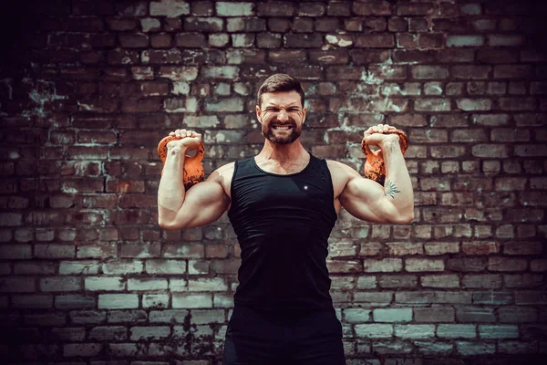 Hombre atlético haciendo ejercicio con un kettlebell. Fuerza y motivación — Foto de Stock