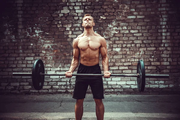 Atletický muž s činka. Sílu a motivaci. Biceps cvičení. — Stock fotografie