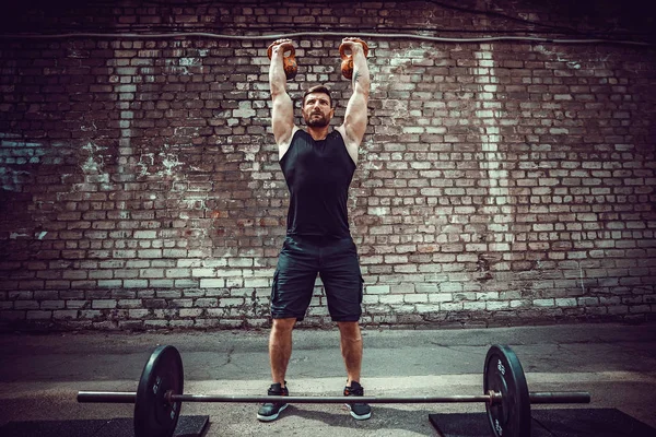 Atletik bir adam bir kettlebell ile çalışma dışarı. Güç ve motivasyon