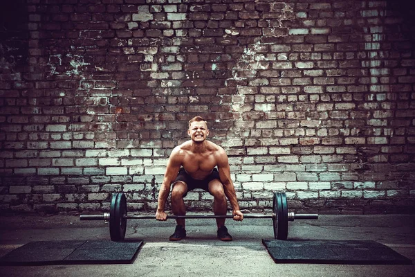Izmos fitness ember csinál deadlift egy súlyzó a fejére, szabadtéri, utcai tornateremben. Funkcionális tréning. — Stock Fotó
