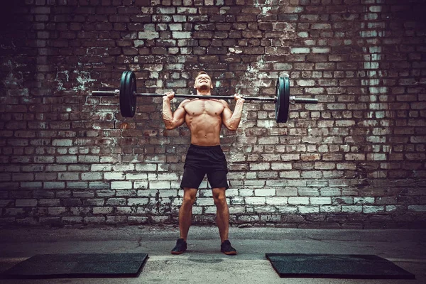 Μυϊκής εκγύμνασης άνθρωπος κάνει deadlift ένα barbell πάνω από το κεφάλι του στην εξωτερική, Οδός γυμναστήριο. Λειτουργική προπόνηση. — Φωτογραφία Αρχείου