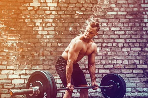 Atletische man uit te werken met een barbell. Sterkte en motivatie. Oefening voor de spieren van de rug — Stockfoto