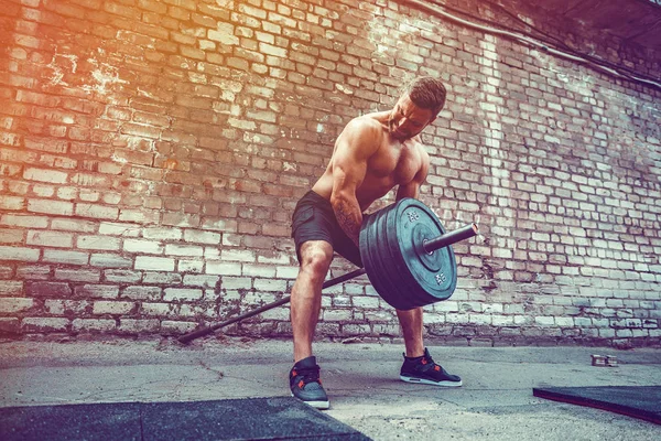 Atletický muž s činka. Sílu a motivaci. Cvičení pro svalstvo zad — Stock fotografie