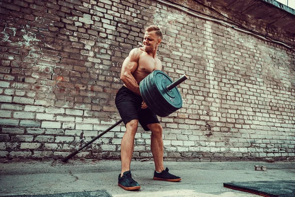 Athletic man working out with a barbell. Strength and motivation. Exercise for the muscles of the back — Stock Photo, Image