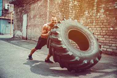 Kas fitness gömleksiz adam büyük lastik taşıma.