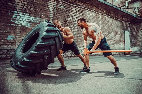 两名肌肉运动员训练。肌肉健身裸男移动大轮胎 — 图库照片