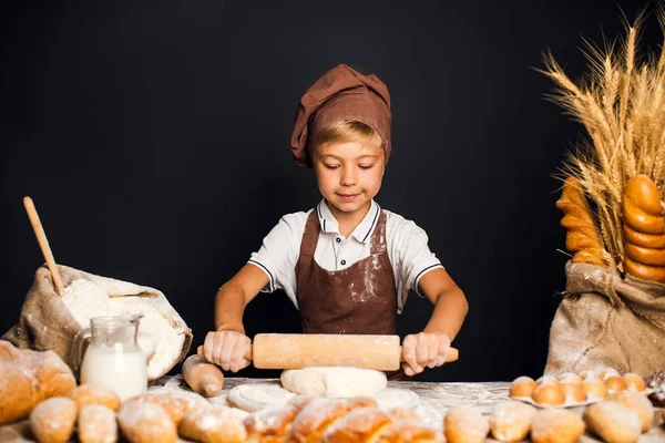 Söt liten pojke med kock hat matlagning — Stockfoto