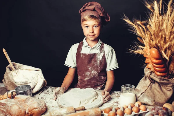 Söt liten pojke med kock hat matlagning — Stockfoto