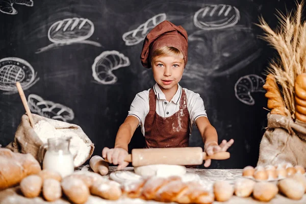 Söt liten pojke med kock hat matlagning — Stockfoto