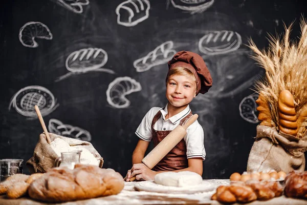 Söt liten pojke med kock hat matlagning — Stockfoto