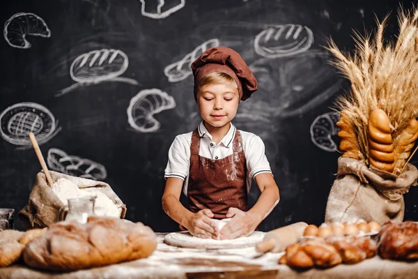 Söt liten pojke med kock hat matlagning — Stockfoto