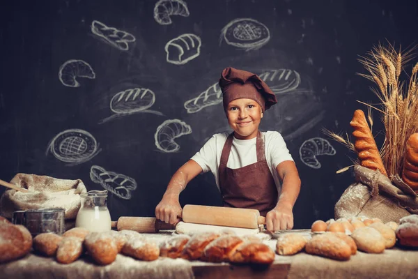 Söt pojke med kock hatt matlagning — Stockfoto