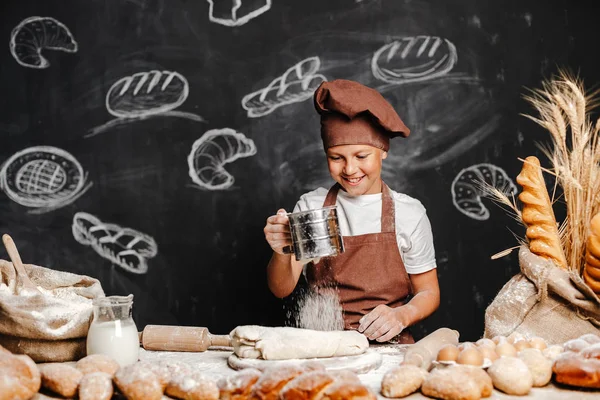 Söt pojke med kock hatt matlagning — Stockfoto