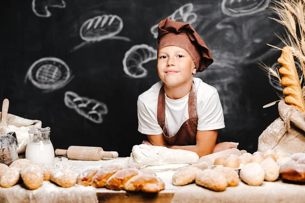 Söt pojke med kock hatt matlagning — Stockfoto