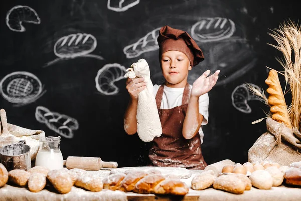 Söt pojke med kock hatt matlagning — Stockfoto