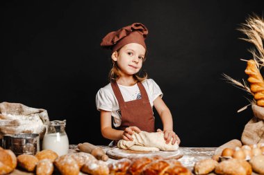 Küçük kız masada hamur yoğurma