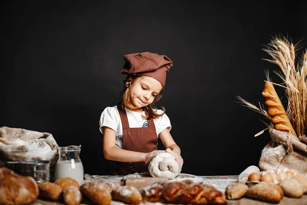 Liten flicka knåda deg på bordet — Stockfoto