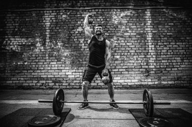 Atletik bir adam bir kettlebell ile çalışma dışarı. Güç ve motivasyon