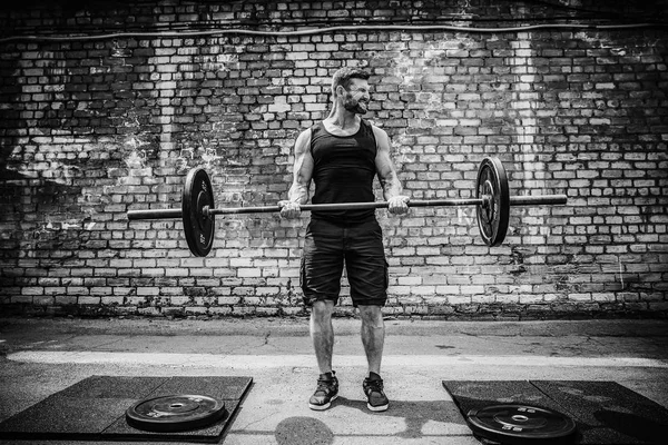 Izmos fitness ember csinál deadlift egy súlyzó a fejére, szabadtéri, utcai tornateremben. Funkcionális tréning. — Stock Fotó