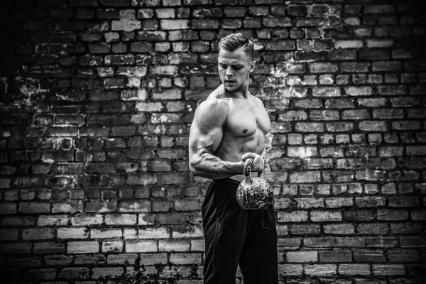 Hombre atlético haciendo ejercicio con un kettlebell. Fuerza y motivación — Foto de Stock