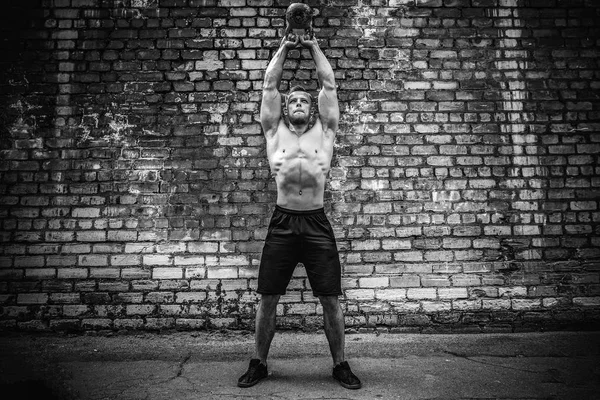 Atletisk man träna med en kettlebell. Styrka och motivation — Stockfoto