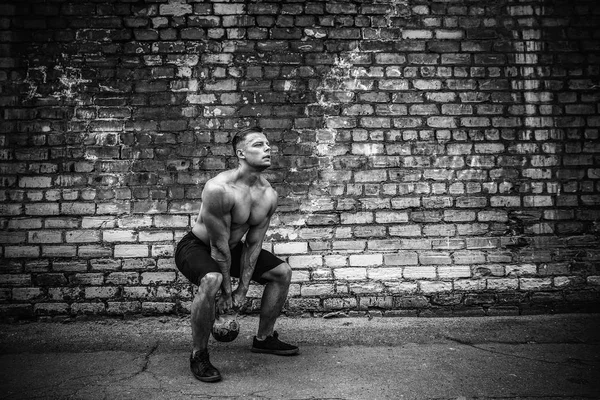 Hombre atlético haciendo ejercicio con un kettlebell. Fuerza y motivación —  Fotos de Stock