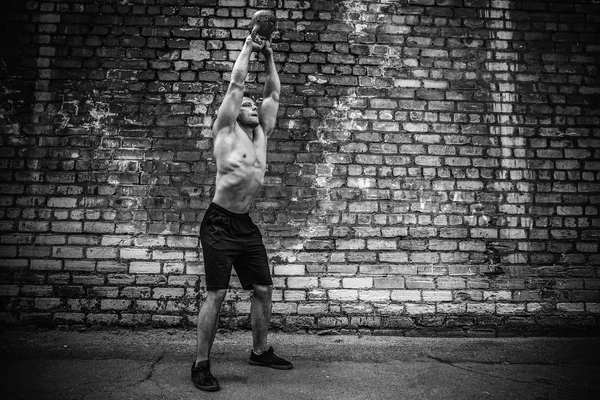Um atlético a treinar com um kettlebell. Força e motivação — Fotografia de Stock