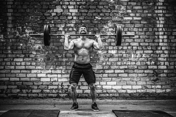 Muscular fitness man doing deadlift a barbell over his head in outdoor, street gym. Functional training. — Stock Photo, Image