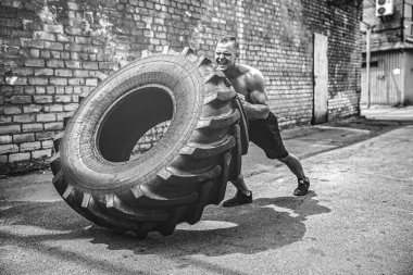 Kas fitness gömleksiz adam büyük lastik taşıma.