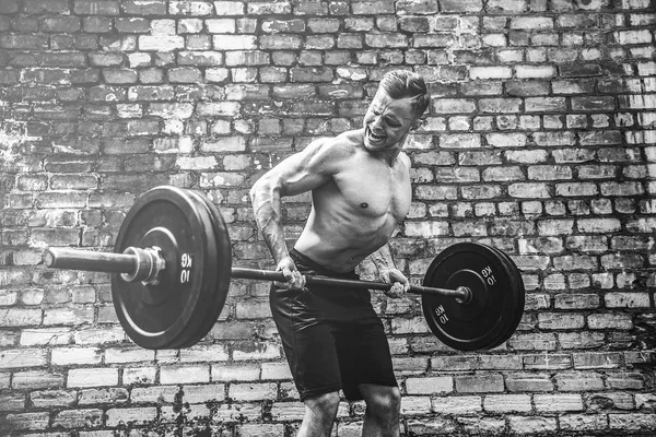 Homem atlético a treinar com um sino. Força e motivação. Exercício para os músculos das costas — Fotografia de Stock