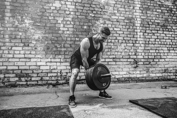 Atletický muž s činka. Sílu a motivaci. Cvičení pro svalstvo zad — Stock fotografie