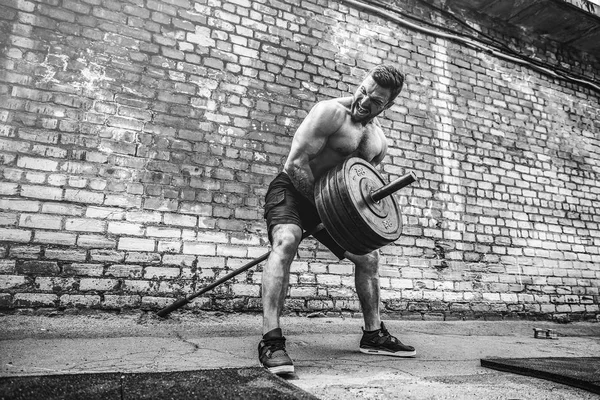 Atletische man uit te werken met een barbell. Sterkte en motivatie. Oefening voor de spieren van de rug — Stockfoto