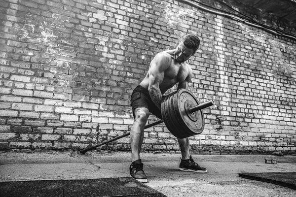Αθλητικός άνδρας που εργάζονται έξω με ένα barbell. Δύναμη και κίνητρο. Άσκηση για τους μυς της πλάτης — Φωτογραφία Αρχείου