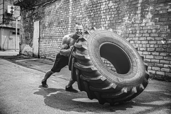 Muscular fitness sin camisa hombre moviendo neumático grande . —  Fotos de Stock